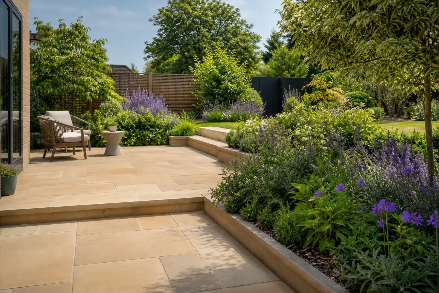 Natural stone patio with paving in a landscaped UK garden